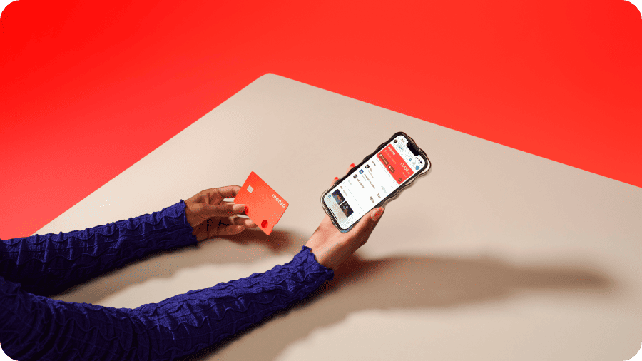 A hand holding a Monzo card.
