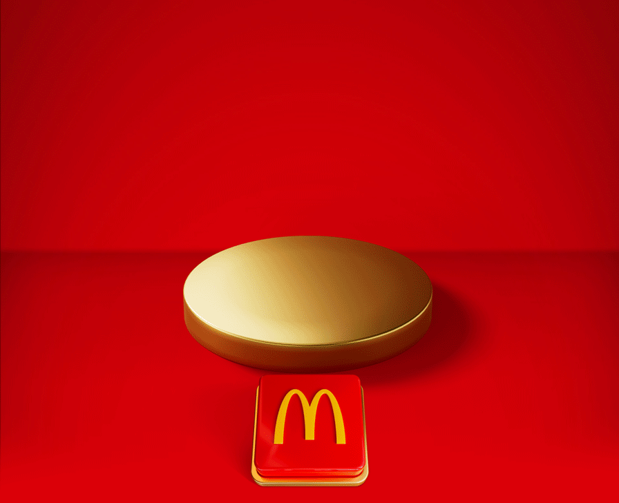 An empty gold plinth sits on a red background with a big red button beneath it. Text reads PUSH THE BUTTON TO REVEAL TOMORROW'S OFFER