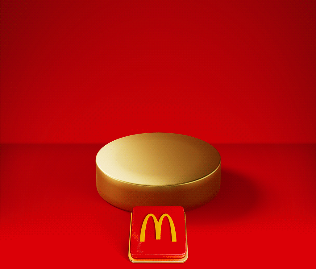 An empty gold plinth sits on a red background with a big red button beneath it. Text reads TAP TO REVEAL MONDAY'S DEAL