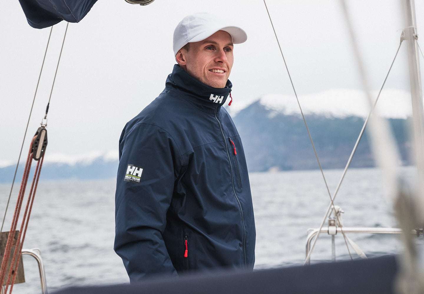 Man on sailboat wearing Crew Midlayer Jacket 2.0