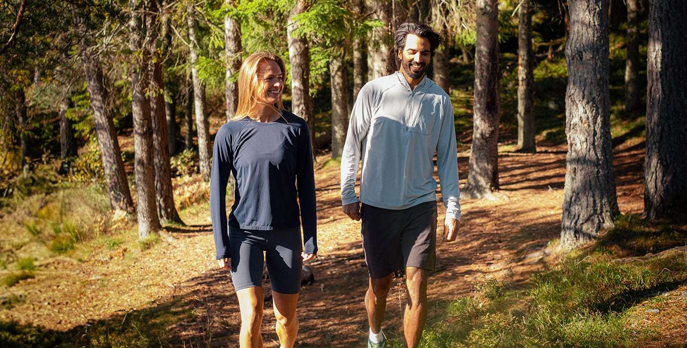 Man and woman hiking, wearing Helly Hansen UPF Protection clothing