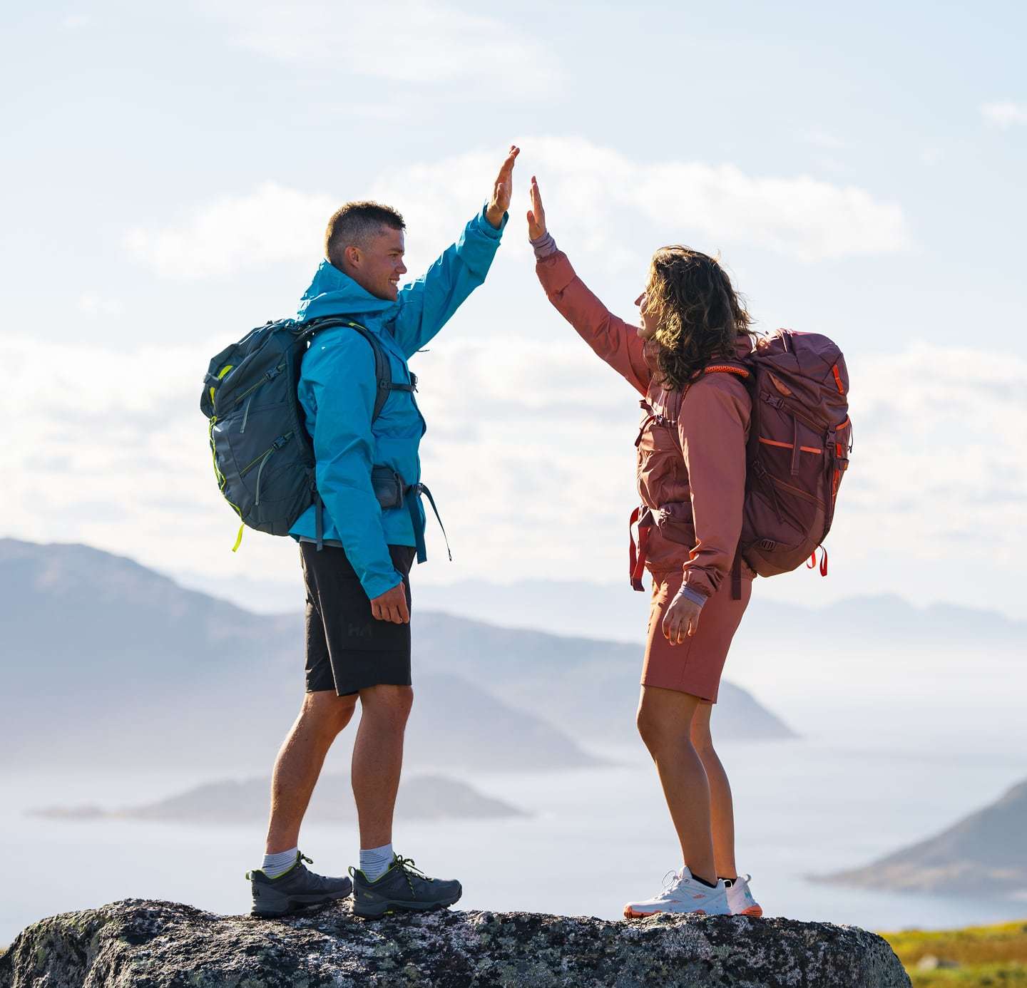 Man and woman on top of mountain in Helly Hansen gear