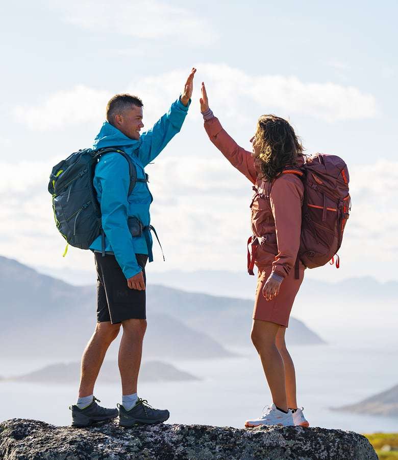 Man and woman on top of mountain in Helly Hansen gear