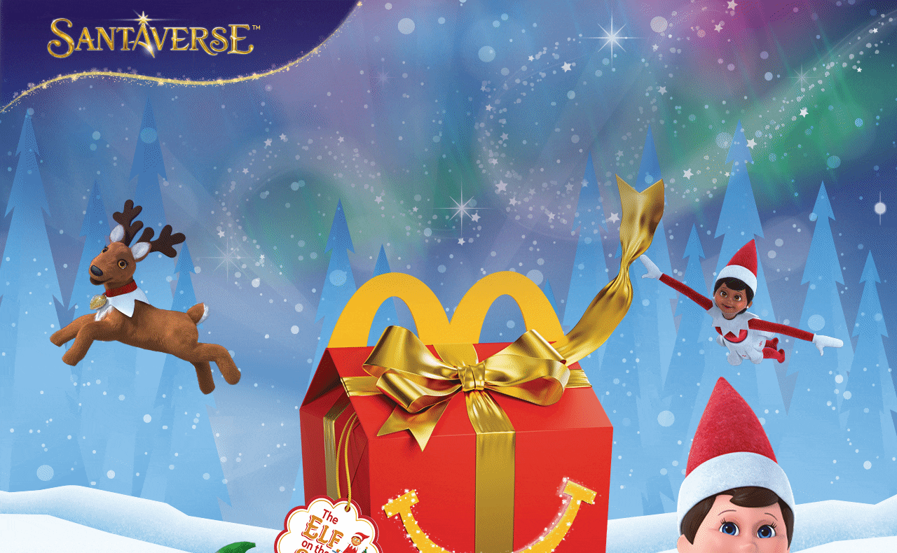 A decorative Happy Meal® box in a festive scene. White text reads 'Tell your happy little helpers The Elf on the Shelf® is here!'
