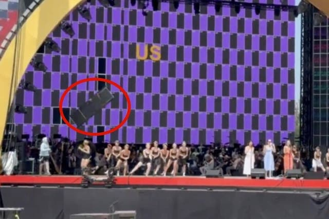 Dancers move for cover as a large object falls to the stage at Trump's Freedom 250 celebration