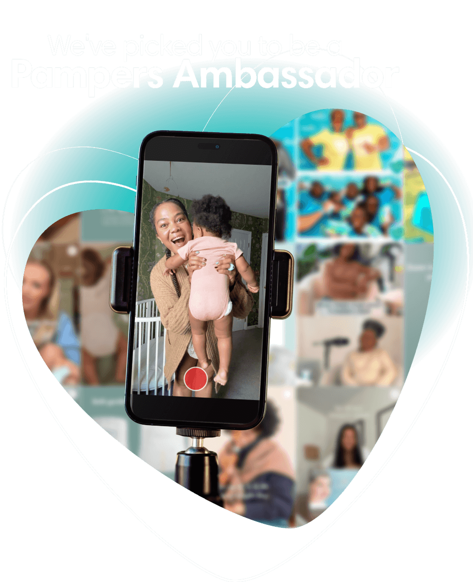 Against the backdrop of a heart outline, there’s a phone that displays the camera screen. The image is a smiling mother holding her baby. In the background, the heart online shows blurred pictures of social media posts. The title reads, “We’ve picked you to be a Pampers Ambassador”.