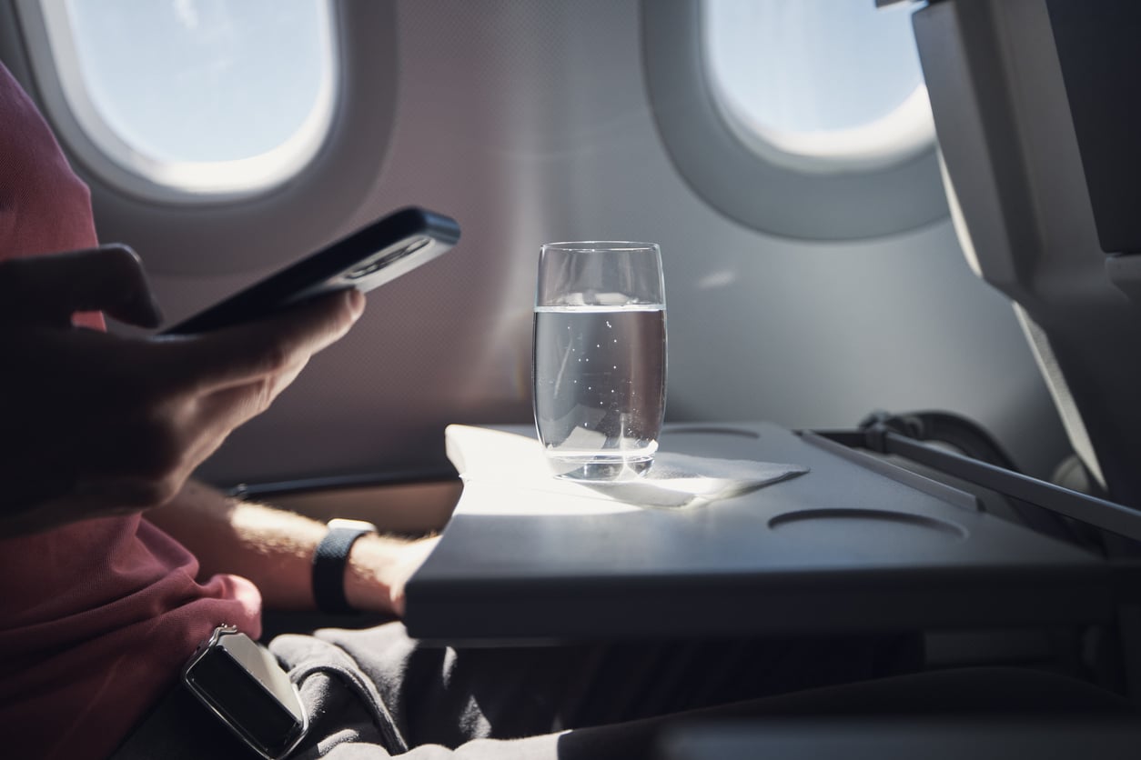 Glass of water on a tray table on a flight